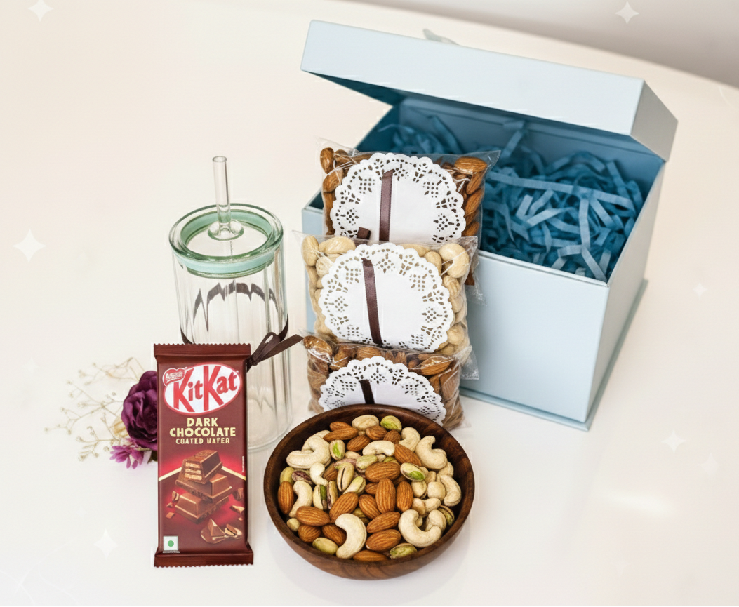 Gourmet gift set with KitKat chocolate bar, cookies, and nuts on a white surface.