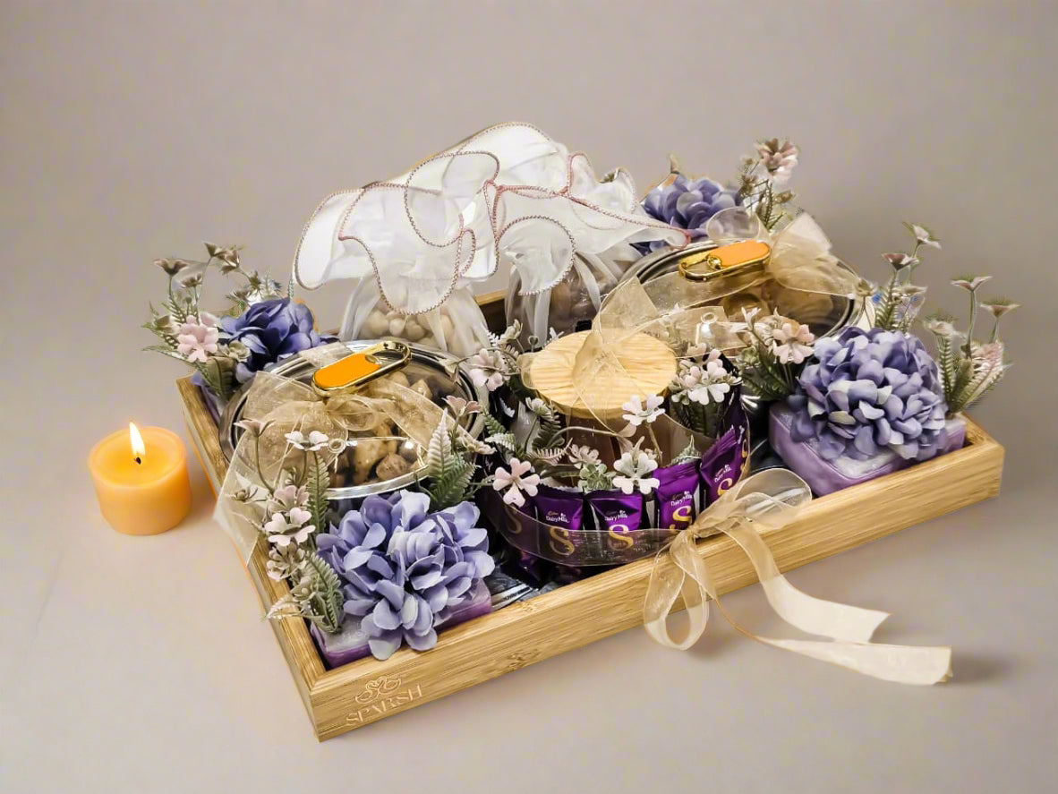 Decorative items including soaps and flowers on a wooden tray with a white background